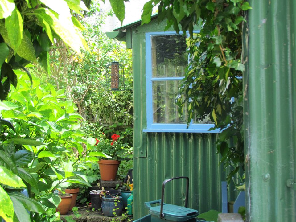 green summer house in a pretty garden