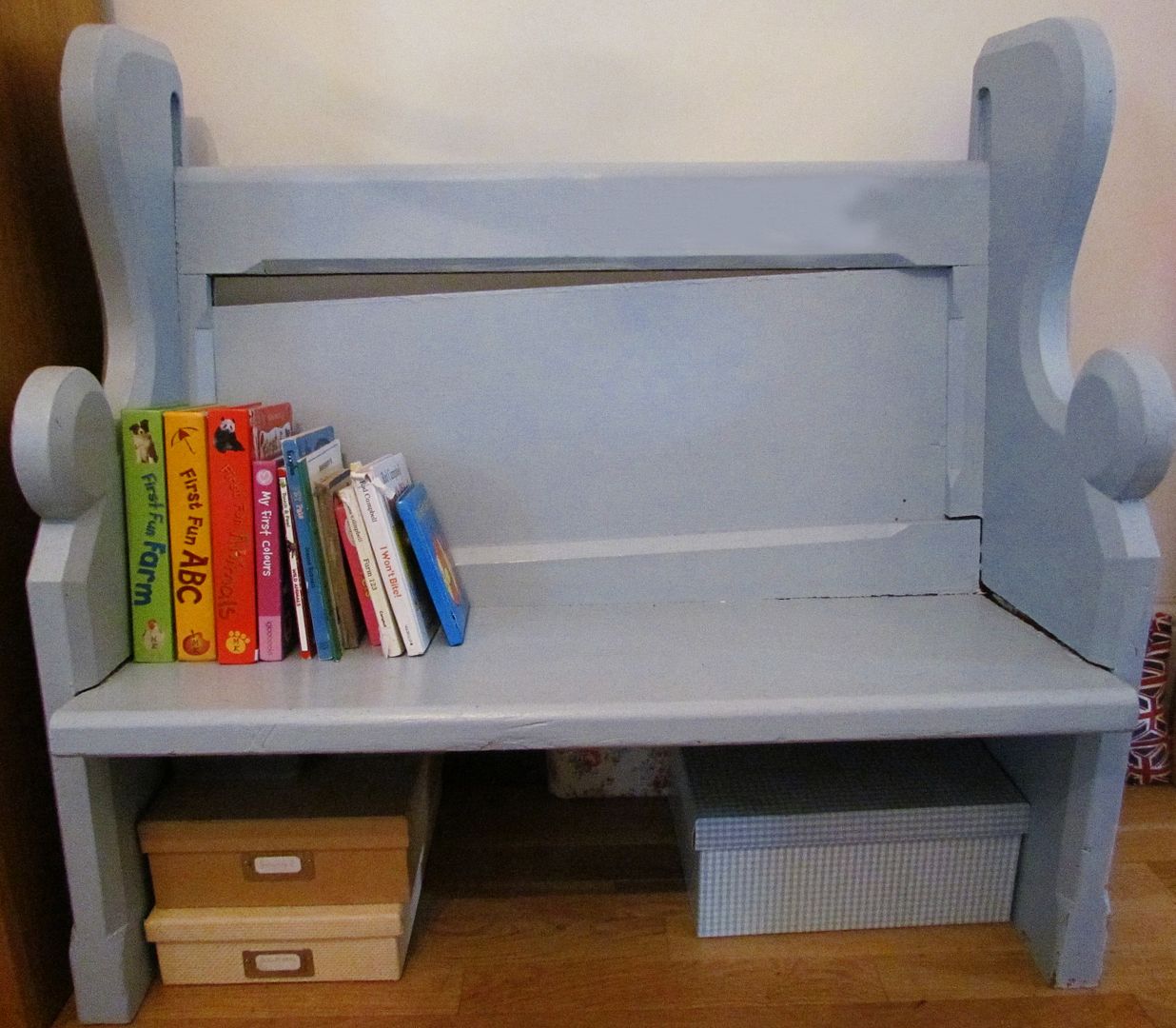 painted blue settle used as a bookshelf