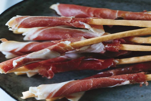 Just ingredients make these Prosciutto Wrapped Grissini a great cocktail party recipe that's easy (and more affordable than a big, fancy meat plate) | Epicurious