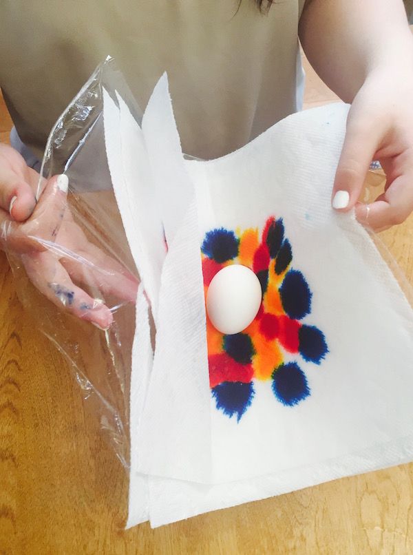 Step 3 in tie-dyed Easter eggs: Wrap your hardboiled egg tightly in the paper towels and plastic wrap.